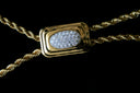 Gold necklace with a diamond-encrusted pendant on a black background